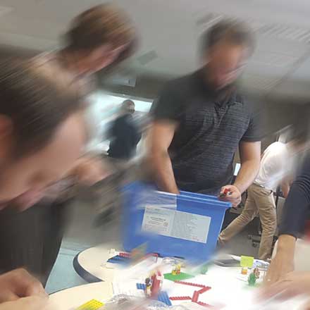 pessoas criando um protótipo numa mesa com legos